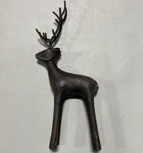 Load image into Gallery viewer, The Cast Iron Deer features a dark brown, minimalist design with prominent antlers, making it a perfect rustic décor accent for any home when displayed on a light gray surface.