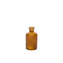 Load image into Gallery viewer, A translucent amber bud vase with a short neck and wide base is displayed against a plain white background.