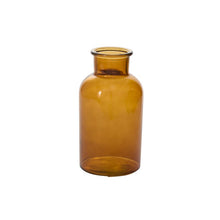 Load image into Gallery viewer, The Transluscent Amber Bud Vase stands upright on a white background; it features clear amber glass and a wide neck, with no cap.