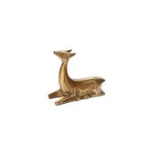 Load image into Gallery viewer, The Golden Prancer Reindeer Figurine is a small brass statue of a deer lying down with its head slightly raised. Featuring a textured surface and stylized details, it’s ideal for holiday décor and shown against a plain white background.