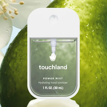 Load image into Gallery viewer, A Touchland Hand Sanitizer Mist with a white top is displayed before a green aloe vera leaf and white flower petals. The 1 fl oz spray hydrates hands and leaves them delicately scented.