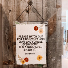 Load image into Gallery viewer, The Lit Decor and Gift Handmade Paper Print, framed and decorated with red and yellow flowers, displays Jim Henson’s quote: “Please watch out for each other and love and forgive everybody. It’s a good life, enjoy it.”.