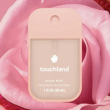 Load image into Gallery viewer, A pink Touchland Hand Sanitizer Mist sits centered against pink rose petals. Its label and fluid ounces are visible, offering hydrated hands with every delicate spritz.