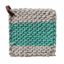 Load image into Gallery viewer, The Crocheted Pot Holder w/ Leather Strap features a thickly knit square design with beige and teal yarn, a central teal stripe, and a brown leather loop in one corner for convenient heat protection in your kitchen.