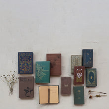 Load image into Gallery viewer, A set of Canvas Journals in 4 styles, some open and some closed, are arranged on a light textured surface with dried flowers scattered nearby.