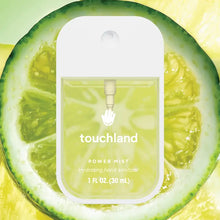 Load image into Gallery viewer, A bottle of Touchland Hand Sanitizer Mist, with yellow-green liquid inside, sits before a sliced lime. The clear label displays the name and 1 fl oz (30 mL) volume—ideal for delicately scented, hydrated hands.