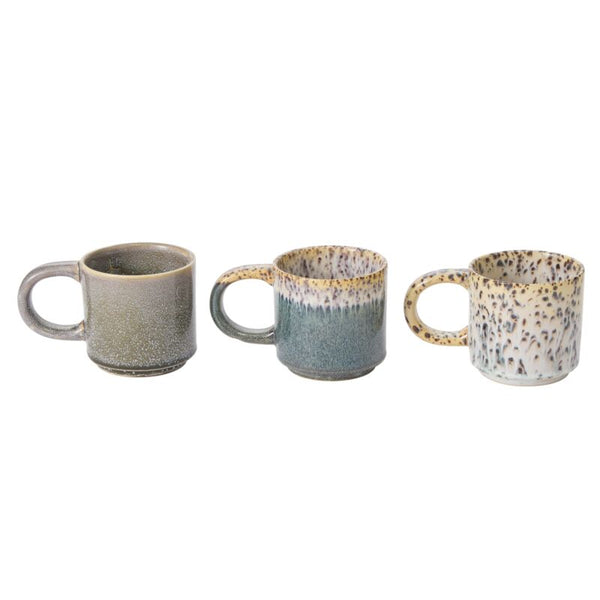 The Starling Mug Collection features three artisanal stoneware mugs with large handles, each boasting a unique reactive glaze: brown, green, and white with black speckles, arranged in a row.