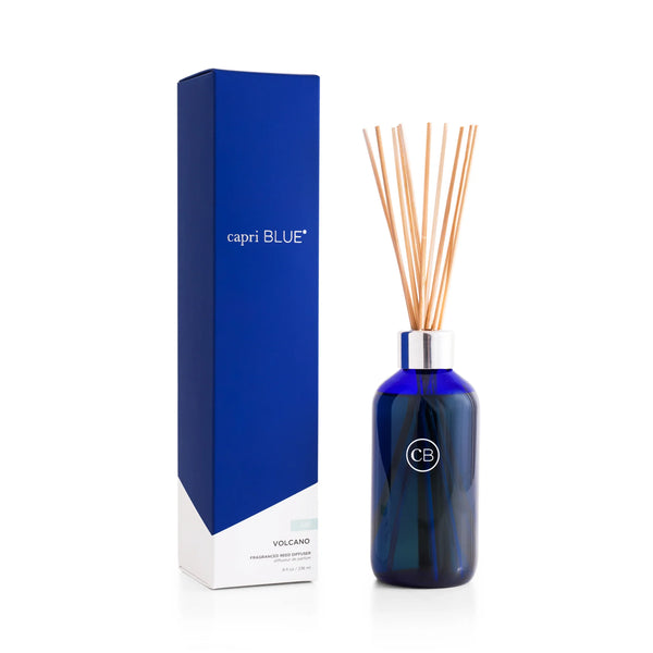 The Volcano Reed Diffuser features a blue glass bottle and several wooden reeds, packaged in a tall, stylish box—ideal for adding flameless fragrance and modern décor to your space.