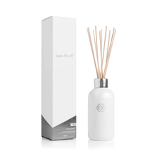 Load image into Gallery viewer, The Volcano Reed Diffuser features a white bottle with a silver cap and multiple reed sticks, paired with sleek white and silver packaging—an ideal flameless fragrance option to enhance any modern home décor.